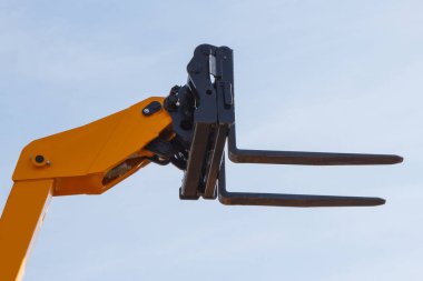 Forklift yükleyici veya istifçi mavi gökyüzü arka plan üzerinde bir parçası. Modern teknoloji