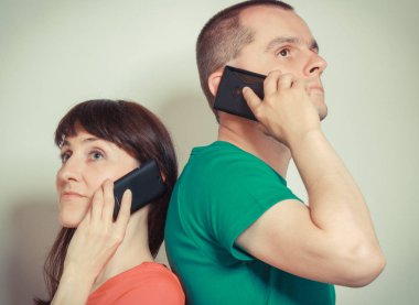 Kadın ve adam farklı sorunlar ya da şeyler hakkında cep telefonu konuşuyor