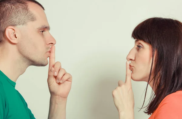 Жінка і чоловік тримає палець на губах і показує знак тиші — стокове фото