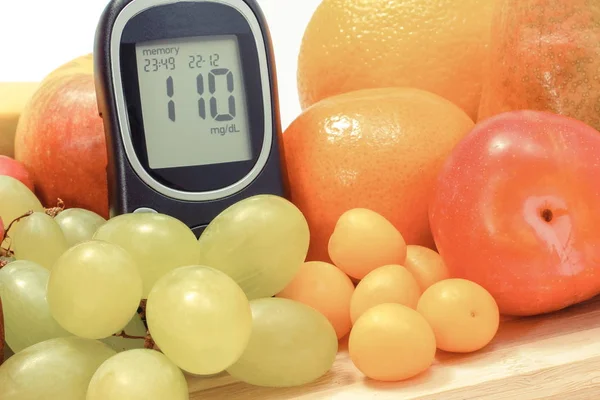 Glucometer sokeri tasolla ja tuoreita hedelmiä. Terveellinen syöminen diabeteksen aikana — kuvapankkivalokuva