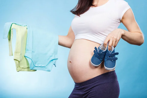 Vrouw in zwanger met kleding voor pasgeborene. Verwacht voor baby — Stockfoto