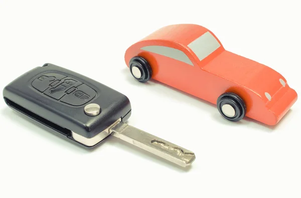 Red toy car and vehicle key on white background — Stock Photo, Image