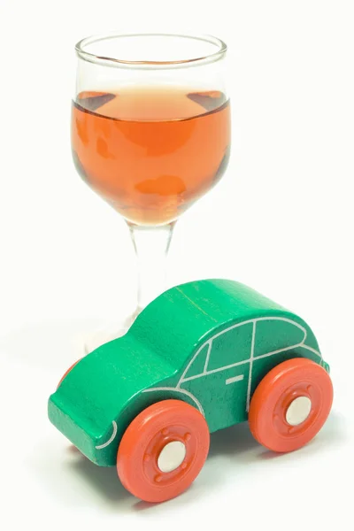 Copa de vino y coche de juguete verde. No bebas y conduzcas concepto. Fondo blanco — Foto de Stock