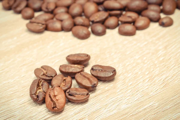 Altura de grãos de café em tábua de madeira — Fotografia de Stock