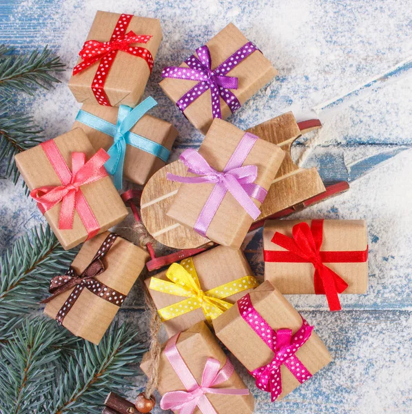 Ramas de abeto y trineo de madera con regalos envueltos para Navidad — Foto de Stock