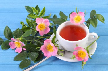 Fincan çay ve mavi kurullarında yabani gül çiçek