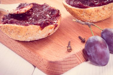 Tahta bıçak ve erik reçelli taze sandviçler ya da tahta kesme tahtasında reçel.