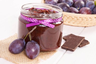 Cam kavanozda erik reçeli, sepsiyonda meyve ve çikolata, tatlı tatlı konsepti.