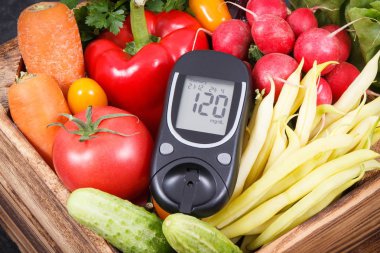 Glikoz ölçer şeker seviyesinde ve taze olgun sebzeler tahta kutuda vitamin içeren sağlıklı atıştırmalıklar gibi