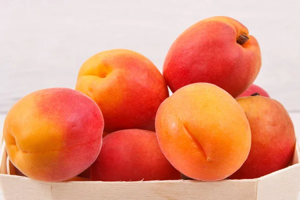 Apricot or peach in wooden box as healthy snack or dessert. Food containing vitamins and minerals — Stock Photo, Image