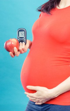 Elma ve glikoz metresi olan hamile bir kadın ve şeker seviyesi iyi. Hamilelik boyunca diyabet ve sağlıklı beslenme