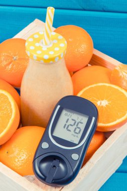 Şeker seviyesi ve narenciye gelen coctail veya smoothie ile Glucometer. Diyabet ve sağlıklı çerez mineraller ve vitaminler içeren