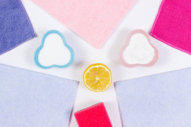 Evde farklı yüzeyleri temizlemek için renkli aksesuarlar ve doğal deterjanlar, beyaz arka plan