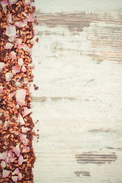 Vintage photo, Dried wild rose petals and tea grains on old board, copy space for text — Stock Photo, Image