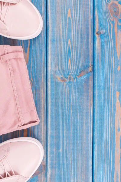 Kadınsı pembe deri ayakkabılar ve pantolonlar, metin için kopyalama alanı veya eski mavi tahtalara yazma alanı