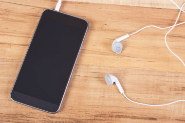 Cep telefonu, ahşap tahta üzerinde kulaklık ile smartphone