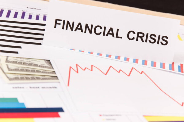 Inscription financial crisis, currencies dollar and downward graphs representing financial crash caused by coronavirus. Covid-19. Sars-CoV-2. 2019-nCoV