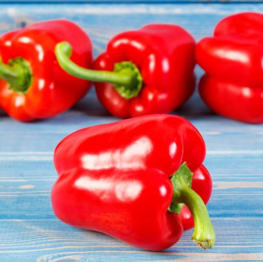 Mavi panolarda duran taze kırmızı biber, sağlıklı beslenme kavramı.