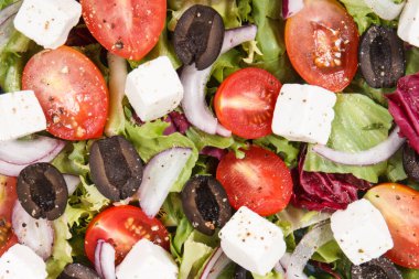 Doğal vitamin ve mineral içeren sağlıklı bir yemek olarak feta peynirli ve sebzeli taze Yunan salatası.