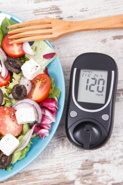 Glikoz ölçer ve taze Yunan salatası, yanında da peynir ve sebze. Şeker hastaları, diyet ve zayıflama için en sağlıklı yiyecekler.