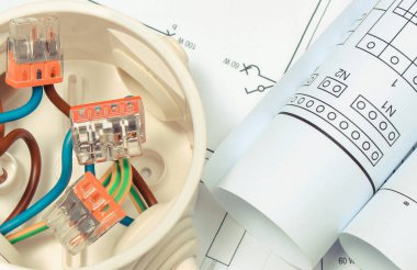 Elektrik kablosu, bakır kablolar ve bina çizimleriyle dolu. Elektrik tesisatlarında kullanılan bileşenler. Mühendislik işleri için aksesuarlar