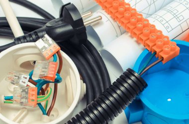 Elektrik kutusu, fiş ve küp, birbirine bağlı bakır kablolar ve ev çizimleri. Elektrik tesisatları için bileşenler ve aksesuarlar