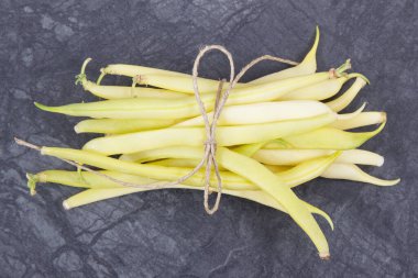 Koyu arkaplanda mineraller ve vitaminler içeren taze taze fasulyeler.