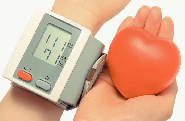 血圧モニターと手に赤い心臓の形 医学と健康的なライフスタイル — ストック写真
