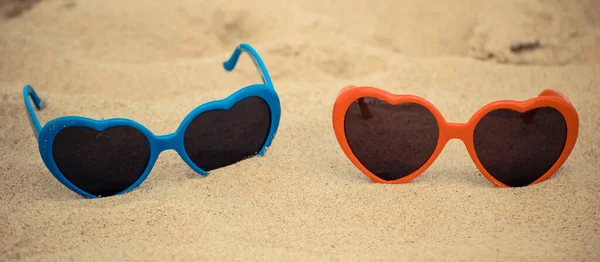 海滩上 蓝色和红色的太阳镜 心形在沙滩上 夏季时间和假期概念 — 图库照片
