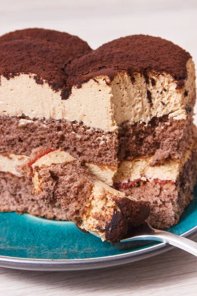 Tasty creamy tiramisu cake on glass plate. Delicious dessert for different occasions or holidays