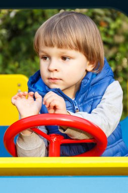 Parktaki çocuk parkında oyuncak arabasıyla oynayan küçük mutlu çocuk. Çocuk gelişimi kavramı