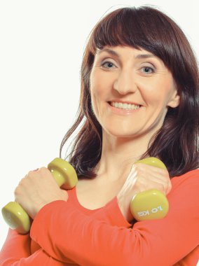 Beyaz arka planda dambıllarla egzersiz yapan bir kadın. Sağlıklı yaşam tarzları ve spor