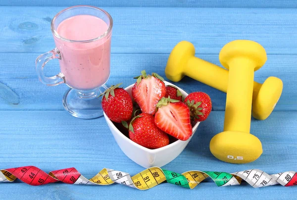 新鲜成熟的草莓 一杯美味的奶昔 健美的哑铃和餐桌上的带子 运动的生活方式 — 图库照片