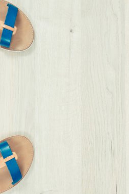 Beyaz tahtada bir çift kadın deri sandaleti, tatilde kullanılacak ayakkabı konsepti, yazı veya yazı için kopya alanı