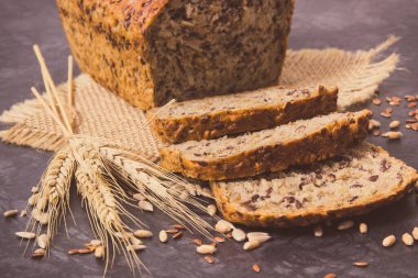 Fırında pişmiş kepekli ekmek, pişirme malzemeleri ve çavdar ya da buğday taneleri. Vintage fotoğraf