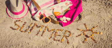 Yazın, kehribar taşı ve aksesuarlardan oluşan güneş şeklinde bir yazı. Rahatlamak için ya da kumsalda güneşlenmek için. Seyahat, turizm ve tatil zamanı kavramı