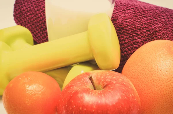 Fitness için taze meyve ve dambıl. Zayıflama, sağlıklı beslenme ve sportif yaşam tarzları