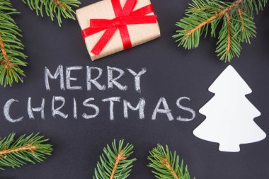 Yazı, Mutlu Noeller, kurdeleli hediye, Noel ağacı şekilli ve yeşil ladin dallı. Noel zamanı için dekorasyon