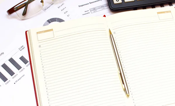 Finansal açıklamalar arasında bir defter var. Ofis masası.