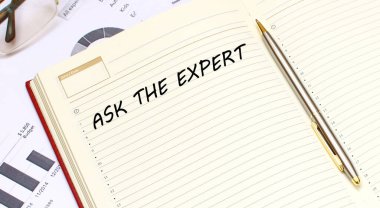 İçinde metin olan açık bir günlük, mali tabloların olduğu bir ofis masasında duruyor. İş konsepti.