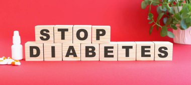 STOP DIABETES kelimesi tıbbi ilaçlı kırmızı arka planda bulunan tahta küplerden yapılmıştır. Tıbbi konsept.