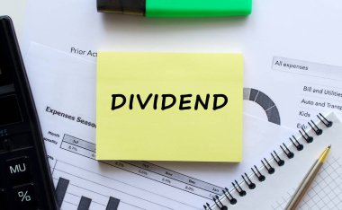 Ofis malzemelerinin yanında beyaz bir arkaplanda DÖKD mesajı olan bir not. Kalem ve hesap makinesi. İş konsepti.