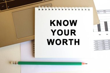 Metni olan not defteri dizüstü bilgisayarın klavyesinde. Asgari çalışma alanı. İş konsepti.