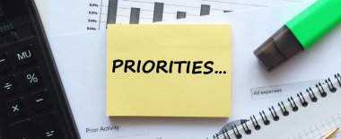 Beyaz arka planda, ofis malzemelerinin yanında yazılı not defteri. Kalem ve hesap makinesi. İş konsepti.