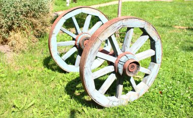 Çimlerin üzerinde eski ahşap tekerlekler. Eski konsept.