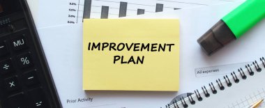 Beyaz arka planda, ofis malzemelerinin yanında yazılı not defteri. Kalem ve hesap makinesi. İş konsepti.