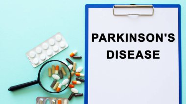 İçinde kağıt olan bir pano uyuşturucu ve şırınganın yanındaki masada yatıyor. Yazıt Parkları Hastalığı 'ndan. Tıbbi konsept.