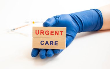 Tıbbi koruyucu eldivenlerdeki eller üzerinde yazı olan tahta küpleri tutuyor. Tıbbi konsept