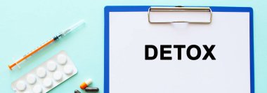 İçinde kağıt olan bir pano uyuşturucu ve şırınganın yanındaki masada yatıyor. Yazıt detoks. Tıbbi konsept.