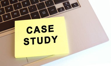 Metni olan not defteri dizüstü bilgisayarın klavyesinde. Asgari çalışma alanı. İş konsepti.